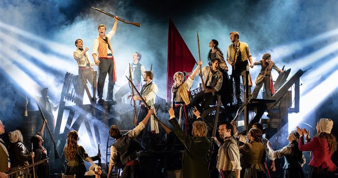 Enjolras (Will Richardson) leads the student chorus at the barricade