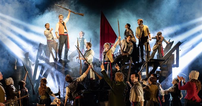 Enjolras (Will Richardson) leads the student chorus at the barricade